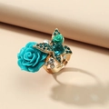 Bohemian golden ring with a blue resin rose and a crystal butterfly on a beige background - Lake Blue