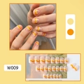 Detail view of W009 press-on nails featuring yellow and orange wave pattern design - W009 Orange Yellow Lines