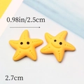 Detail showing two yellow resin starfish charms for DIY crafts with size 2.5cm scale - Yellow Starfish