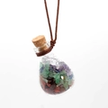 Detailed close-up of crystal gravel inside a glass bottle pendant with cork stopper - Rainbow Stone