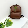 Détail d'un sac à dos marron en similicuir avec broderie champignon et fermeture éclair dorée - Marron