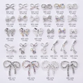 Macro detail of various alloy bowknot nail art charms with pearls and rhinestones - White Rhinestone Bowknot (AA52) / Silver