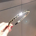 Elegante cerchietto a catena dorata con cristalli neri mostrato in un primo piano a mano - Cristallo Nero