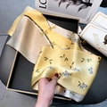 Yellow floral mulberry silk scarf with gold trim displayed on a luxury leather chair - Willow Floral