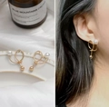 Golden knot hoop earrings with white pearl detail shown on a model and a still life - Gold Knotted Pearl Earrings