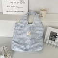 Détail du sac cabas en toile à carreaux bleus avec broderie nœud délicate et étiquette tissée - Grille Bleue Noeud Bleu