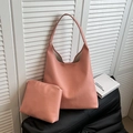 Pink-orange litchi textured leather tote bag with matching inner pouch on a sleek black seat - Litchi Pattern Pink