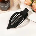 Minimalist matte black oval hair claw clip shown in an elegant lifestyle setting - Matte Black