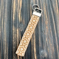 Dettaglio del cordino intrecciato boho arancione e bianco su legno rustico - Arancione e Bianco Geometrico