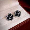 Detail of black camellia flower earrings with rhinestones in a beige velvet jewelry box - Camellia Stud Earrings (46#) / Black-Black Flower