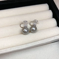 Detailed view of gray pearl clip-on earrings with gold accents in a jewelry box - 34# Ear Clip - Silver Grey Pearl - 12mm
