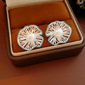Macro detail of silver floral hollow earrings with white pearl and blue trim in a velvet box - Silver Earring Post - Silver - Blue