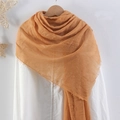 Orange pleated cotton linen scarf with frayed edges hanging on a wooden hanger - Orange