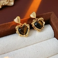 Détail de boucles d'oreilles cœur dorées avec œil de tigre dans un écrin de luxe - Boucles d'Oreilles Coeur Oeil de Tigre - Or (Tige de Boucle d'Oreille en Argent)