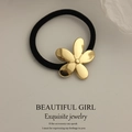 Minimalist elastic hair tie with golden flower metal charm in black and gold finish - Glossy Flower Gold