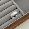 Detalle macro de un anillo de plata con textura de escamas sobre un soporte de joyería - Abierto Ajustable / Plateado