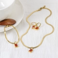 Dettaglio del set di gioielli dorati con collana bracciale e pietre preziose rosse quadrate - Collana+Bracciale+Orecchini Set / Rosso