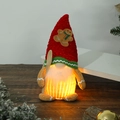 Close-up of a glowing Christmas gnome with LED lights on a rustic wooden surface - Gingerbread Man Glowing Gnome Male