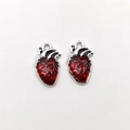 Detail view of two anatomical heart pendants in red enamel and silver zinc alloy metal - Anatomical Heart - Red/Silver