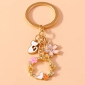 Dettaglio del portachiavi gatto dorato e fiori di ciliegio con corona a cuore di strass - Ghirlanda di Fiori / Oro