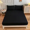 Minimalist black fitted sheet and pillowcase set in a cozy bedroom setting - Black