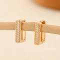 Macro shot of rectangular gold-plated earrings with pavé-set zircons on a wooden twig - EH226 Rectangular Bead Pattern