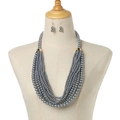 Detail of multi-strand silver-grey pearl necklace and matching earrings on a mannequin - Space Gray