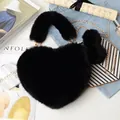 Detailed view of heart-shaped faux fur handbag with gold chain and plush keychain - Black