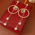 Detail von goldenen Quastenohrringen mit gewebtem Rahmen und Mond-Stern-Kristallen - Gold & Kaffee (Silberstift)