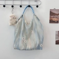 Détail de broderie de fleurs en dentelle blanche sur un sac en soie bleu avec anse en corde - Bleu Marguerite Ondulation de l'Eau
