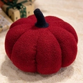 Dark red boucle pumpkin pillow plush with black stem on soft white rug decor - Brick Red