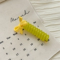 Dettaglio dell'elastico per capelli a spirale con fiocco giallo su uno sfondo di calendario - Anello a Filo del Telefono con Fiocco / Giallo