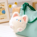 Llavero de gato de peluche blanco con ojos azules colgado en bolso de lona verde - Gato blanco
