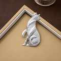 Broche chat vintage en argent au design minimaliste posée sur un coffret cadeau - Argenté