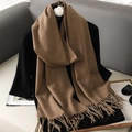 Camel soft cashmere-feel scarf with fringe tassels draped over black clothing - Classic Camel