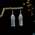 Ethnic silver tassel earrings with leaf-inspired design on a natural wood background - Silver Hollow Top Cover Cylindrical Metal Tassel Style (E4678-1)