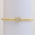 Macro view of gold beaded elastic bracelet with a micro-pave letter W charm detail - Letter W