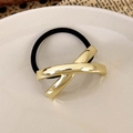 Macro shot of mirror-polished gold X-shaped metal ornament on high-elastic hair tie - Gold Cross