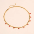 Collar de cadena dorada con múltiples colgantes de corazones rojos de pedrería sobre fondo rosa - Rojo
