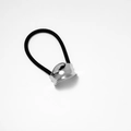 Detail shot of black elastic hair tie with a silver polished wavy metal ornament - Silver