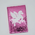 Macro-opname van omkeerbare pailletten met een eenhoorn-silhouet op de notitieboek - Pegasus
