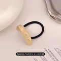 Golden minimalist metal hair tie with irregular texture, measures 5.2cm by 1.3cm - Curved Lava Rock Gold