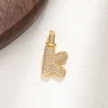 Macro detail of gold-plated K letter pendant with micro-paved cubic zirconia stones - Letter K