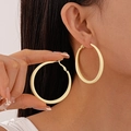Close-up of model wearing matte pastel yellow hoop earrings in a minimalist round style - Yellow Large Hoop