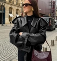 Detail of black faux leather jacket cuff featuring adjustable metal buckle and strap - S / Black