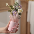 Handheld knitted purple flower bouquet in a pink paper wrap and matching container - With Light + Bag / White + Purple