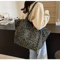 Green leopard print canvas tote bag with front pocket shown in a lifestyle cafe setting - Green Leopard