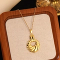 Macro shot of gold spiral twist pendant and fine chain on beige linen display stand - Gold Spiral Pattern Pendant Necklace