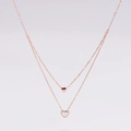 Detalle de collar doble en oro rosa con colgantes de corazón sólido y material blanco - Oro rosa