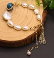 Natural Baroque pearl bracelet with blue bead and gold tassel on wooden background - Natural Freshwater Pearl Strand